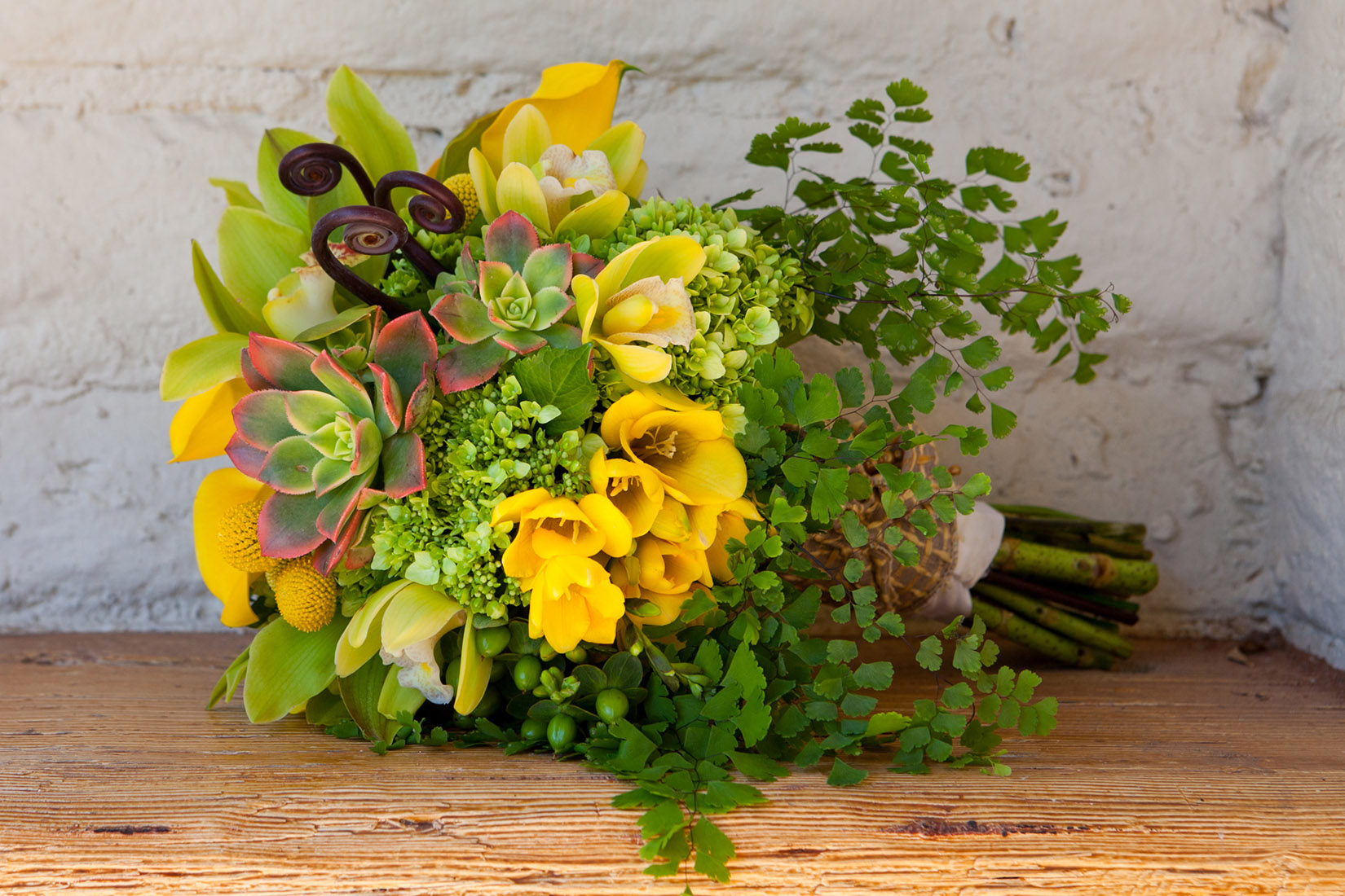 An image of a yellow flower and green succulent bouquet from the Sherman Garden Wedding