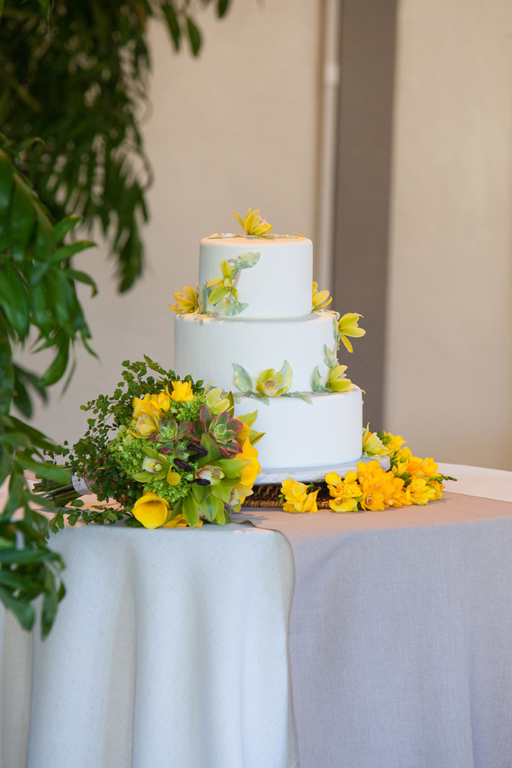 An image of the wedding cake and bouquet of yellow flowers from the Sherman Garden Wedding
