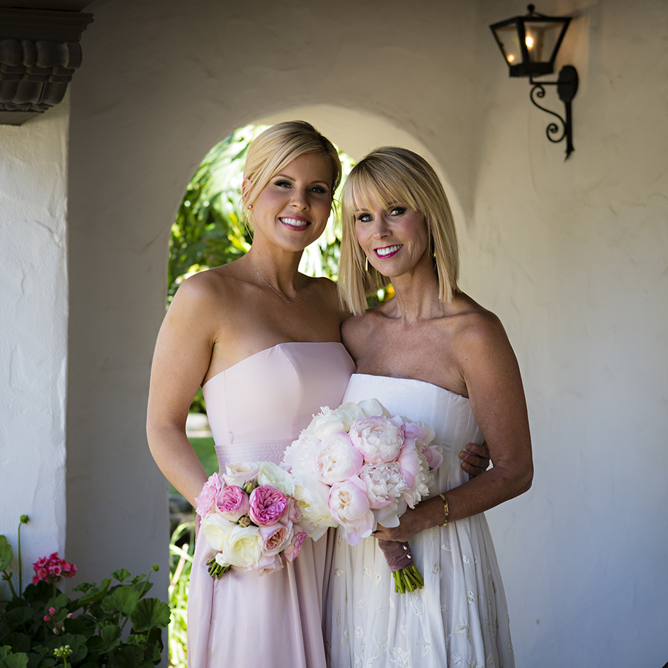 An image of a bridesmaid and the bride holding rose bouquets from the Dunzer Wedding