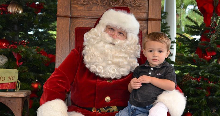 An image of a child posing with Santa