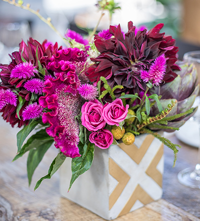 Am image of a dark red dahlia and pink rose floral arrangement
