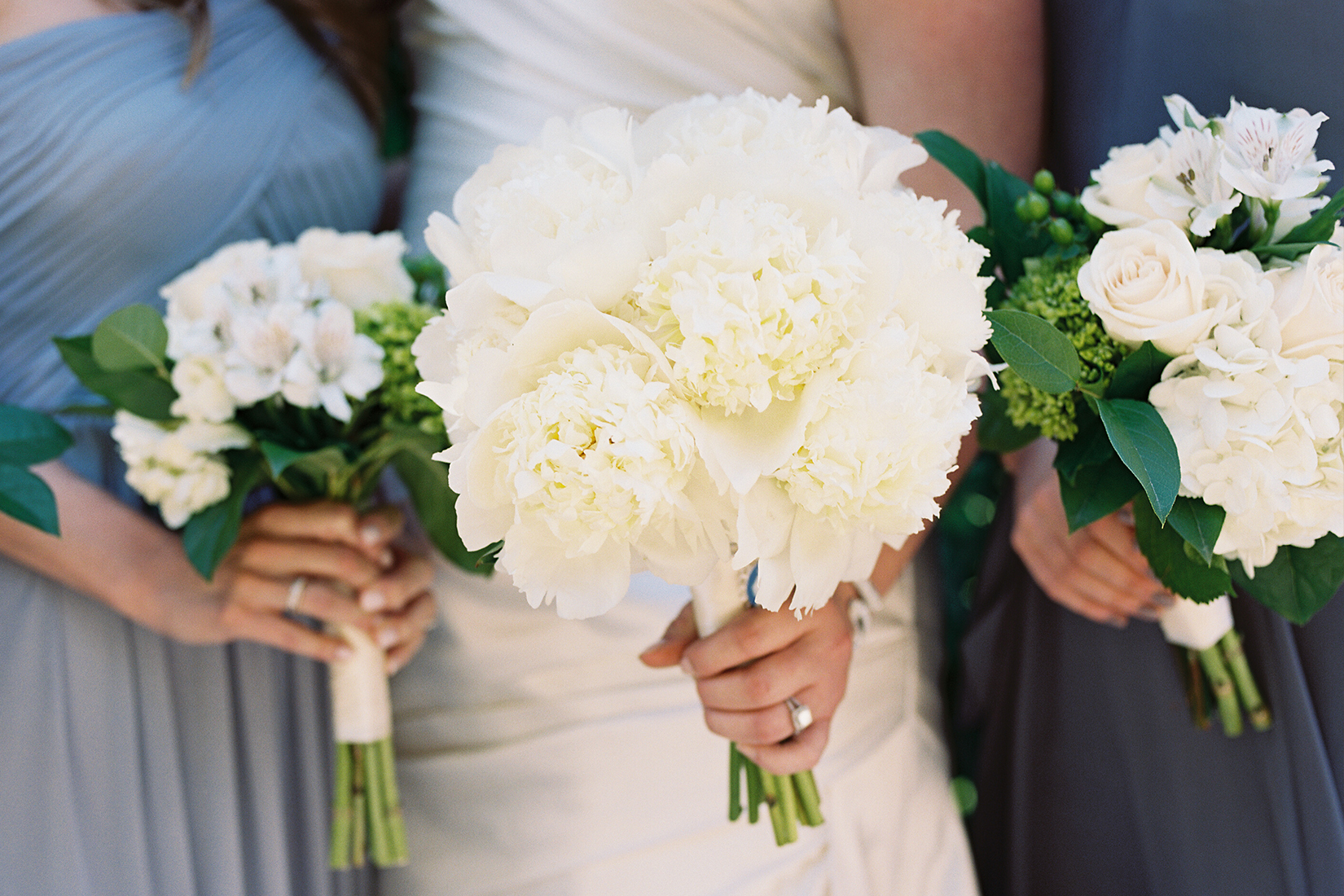 A close up image of the three white flowered wedding bouquets