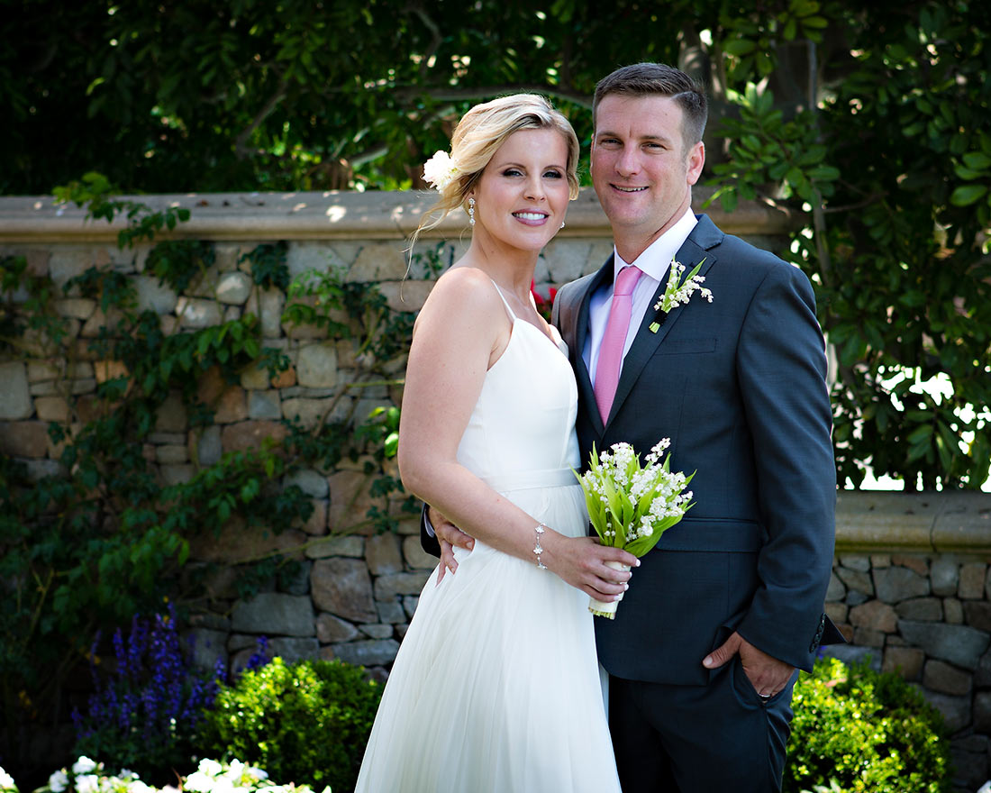 An image of Mr. and Mrs. Dunzer who is holding a simple little white flowered bouquet
