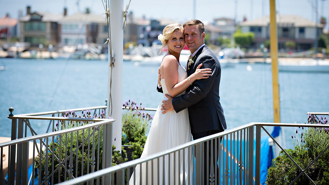 An image of the bride and groom Dunzer posing in front of the harbor