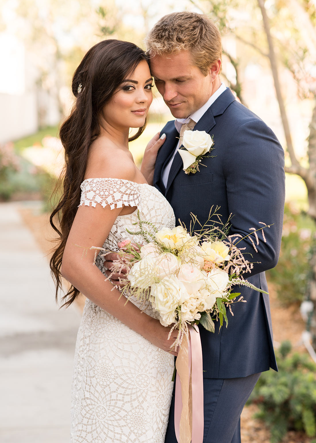 An image of a groom and bride who is holding a white rose bouquet