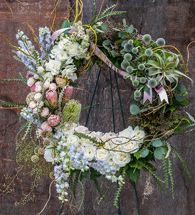 An image of white, light pink and light blue flowers celebration of life wreath