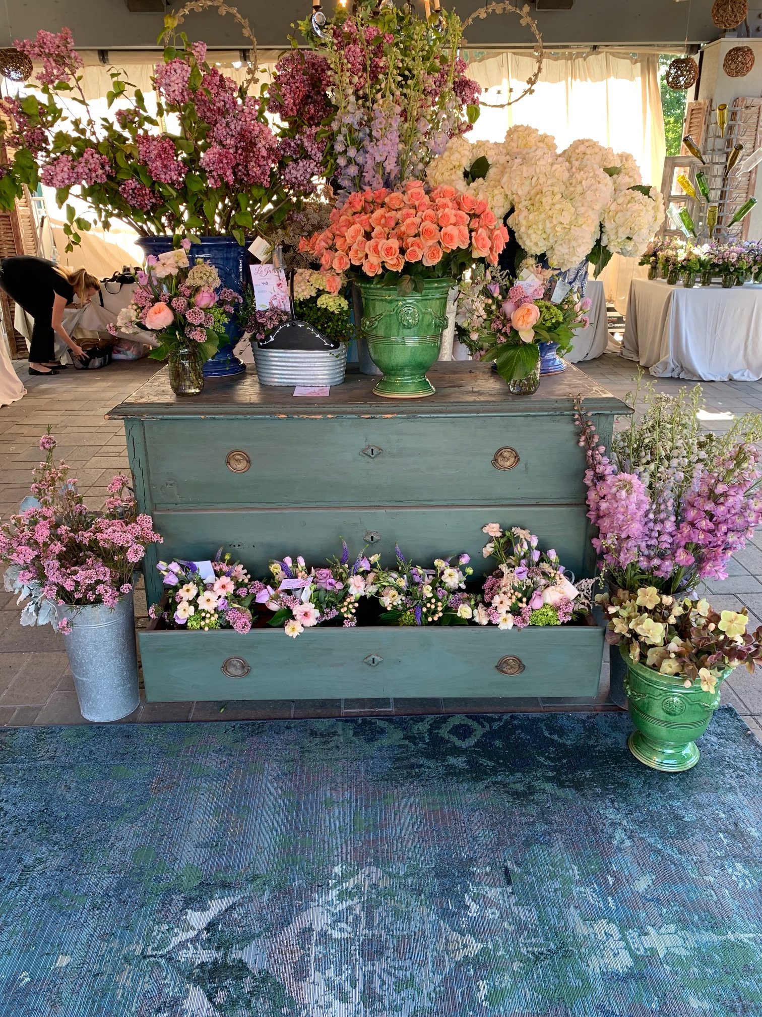 An image of various sorted flowers displayed on a teal chested draws